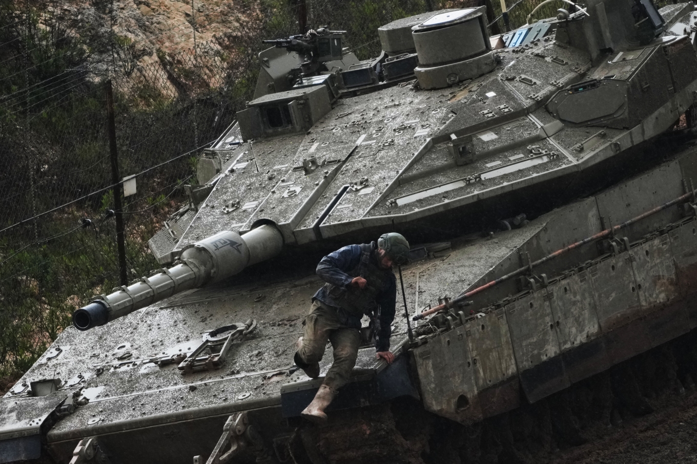 En israelisk soldat hoppar ned från ett pansarfordon i norra Israel, nära gränsen till Libanon. Foto: Ariel Schalit/AP/TT