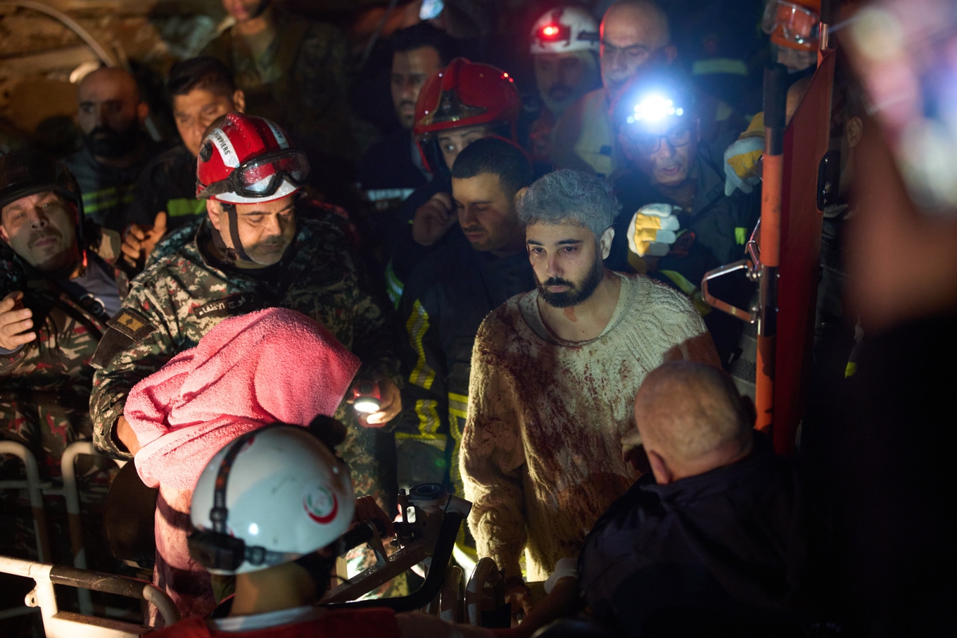 Räddningsarbetare hjälper en man som överlevt ett israeliskt angrepp från en förstörd byggnad i Beirut under onsdagen. Foto: Emilio Morenatti /AP/TT