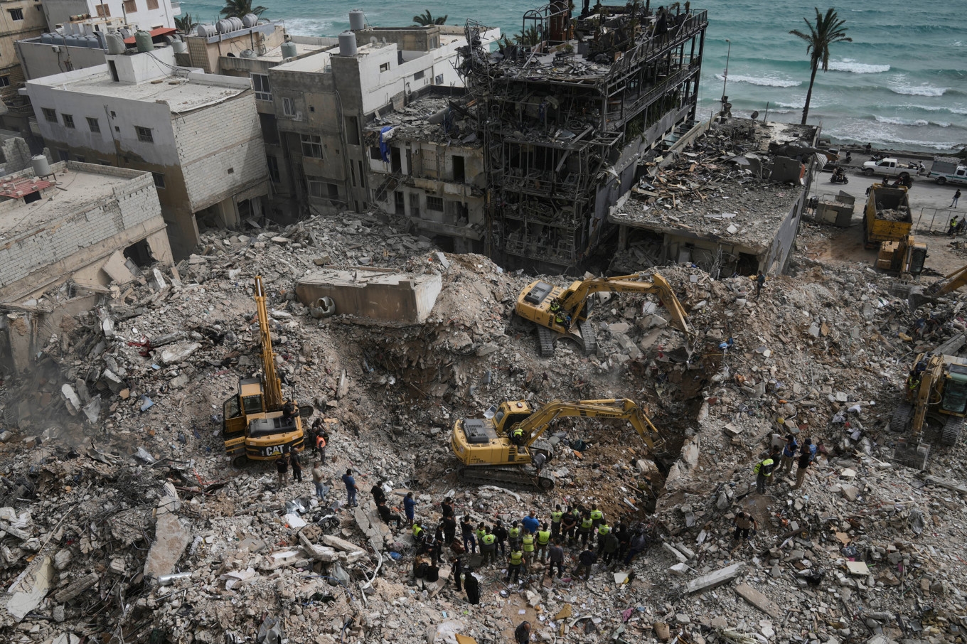 Grävmaskiner rensar bort spillror från byggnader som förstördes i israeliska luftanfall i staden Tyr på torsdagen. Foto: Bilal Hussein/AP/TT