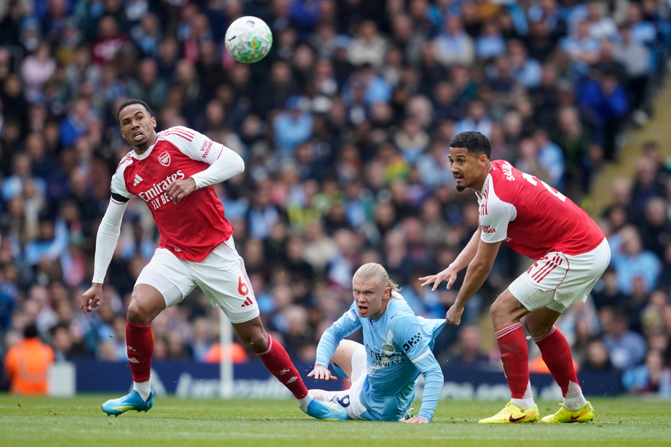 Arsenals spelare bar sorgband i toppmatchen mot Manchester City. Här Gabriel och William Saliba i duell med Erling Braut Haaland. Foto: Dave Thompson/AP/TT