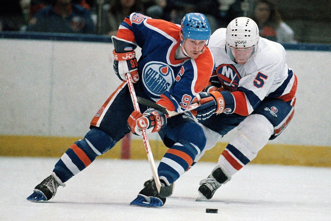 Wayne Gretzky, vänster, i kamp om pucken i en NHL-match 1988 mot New York Islanders. Arkivbild. Foto: Wa Funches/AP/TT