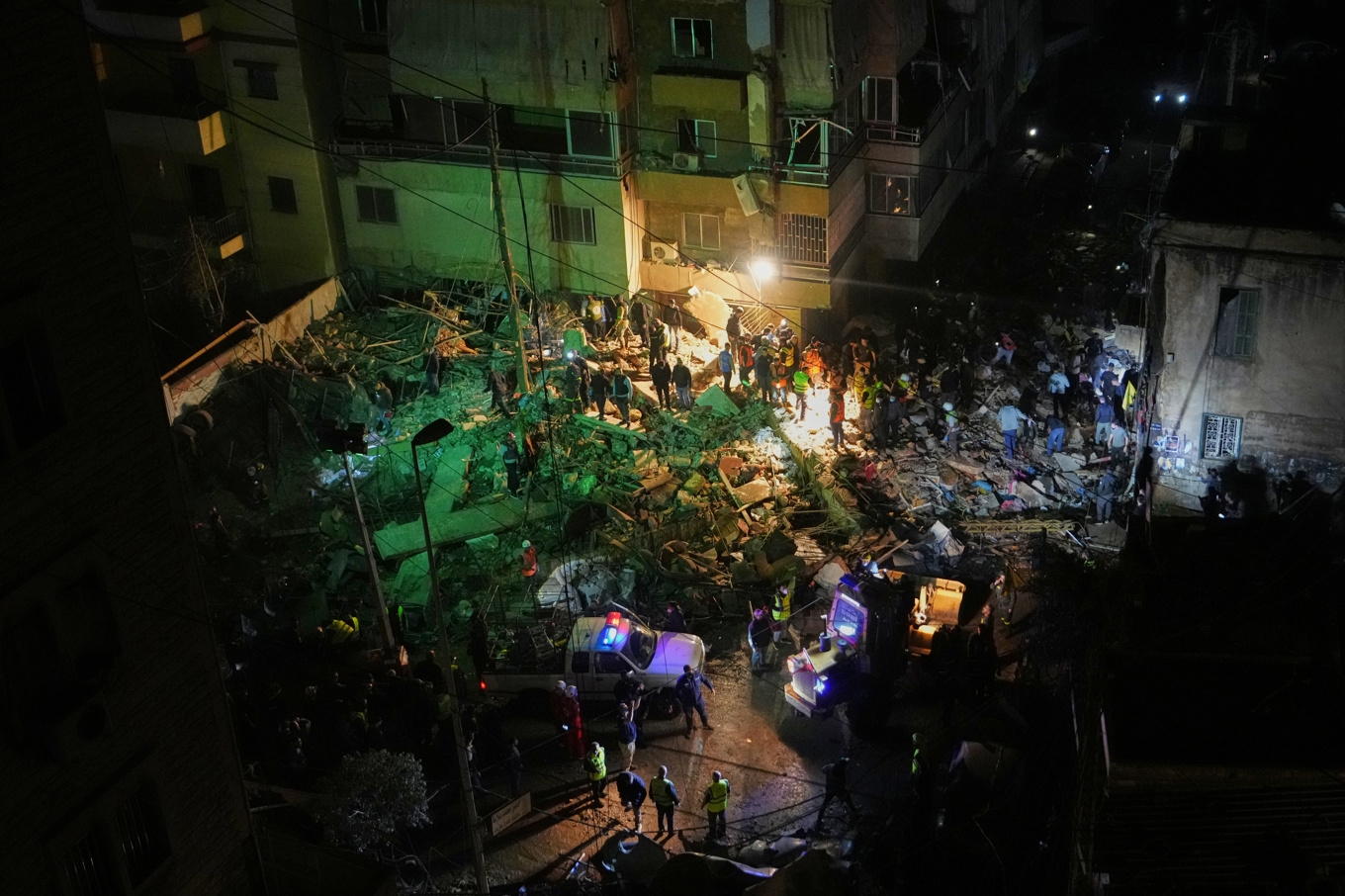 Räddningspersonal söker i rasmassorna efter den israeliska attacken i en förort i södra Beirut. Foto: Hassan Ammar/AP/TT
