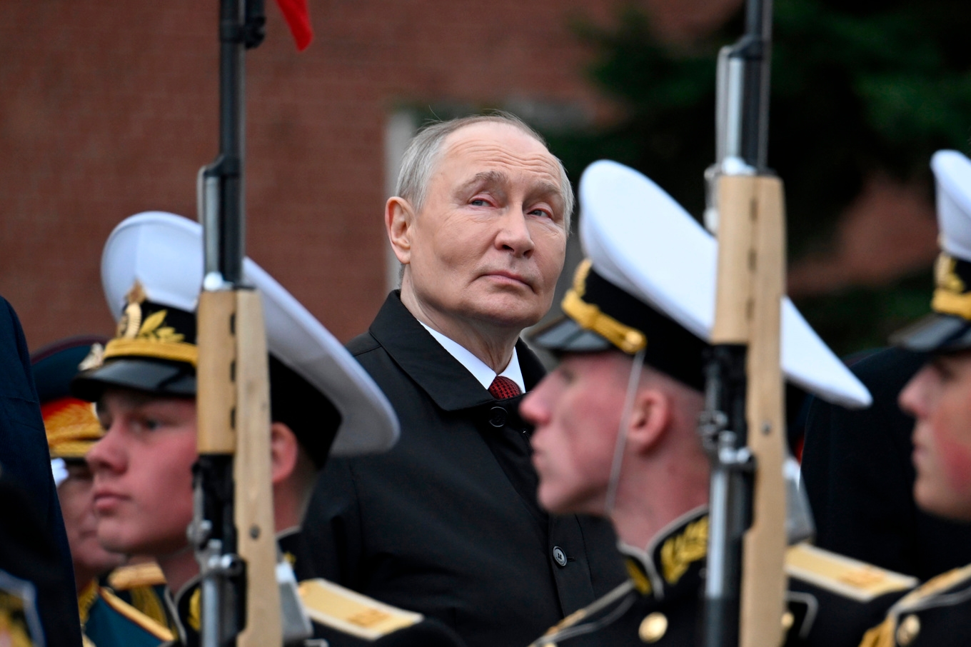 Vladimir Putin bakom led av soldater vid lördagens firande. Foto: Aleksandr Nemenov, pool via AP/TT