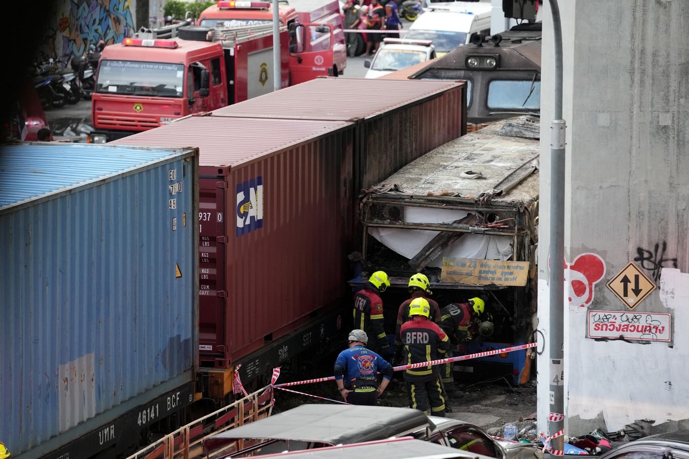 Räddningsarbetare på den plats i Bangkok i Thailand där ett godståg krockade med en buss. Foto: Sakchai Lalit/AP/TT