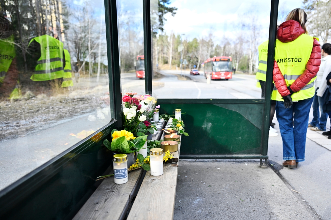 Blommor och ljus i en busskur efter att en man i 18-årsåldern blev skjuten på en buss i Tyresö utanför Stockholm. Arkivbild. Foto: Pontus Lundahl/TT