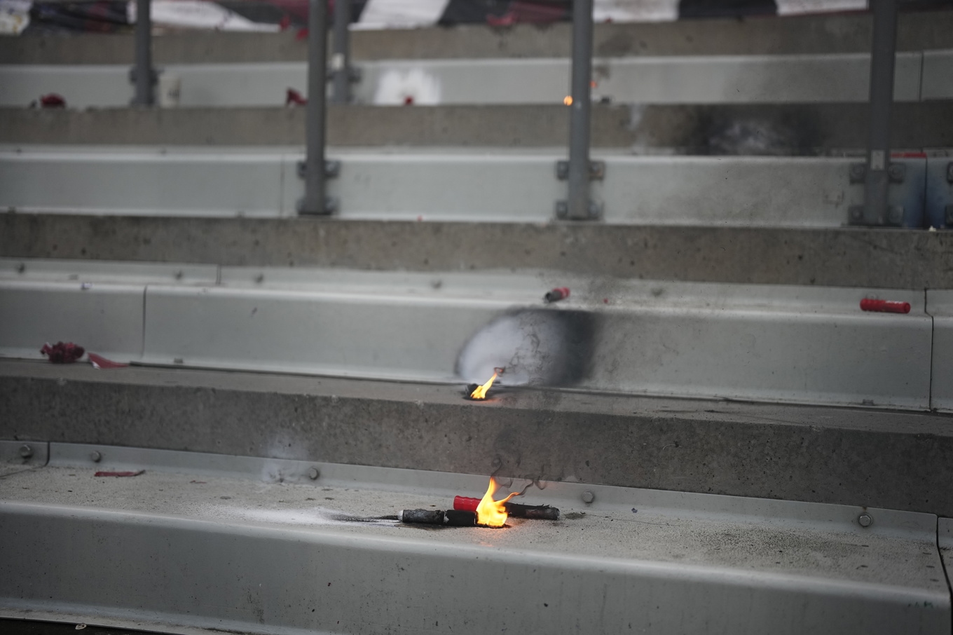 Brinnande pyroteknik på läktaren efter den avbrutna matchen. Foto: Björn Larsson Rosvall/TT