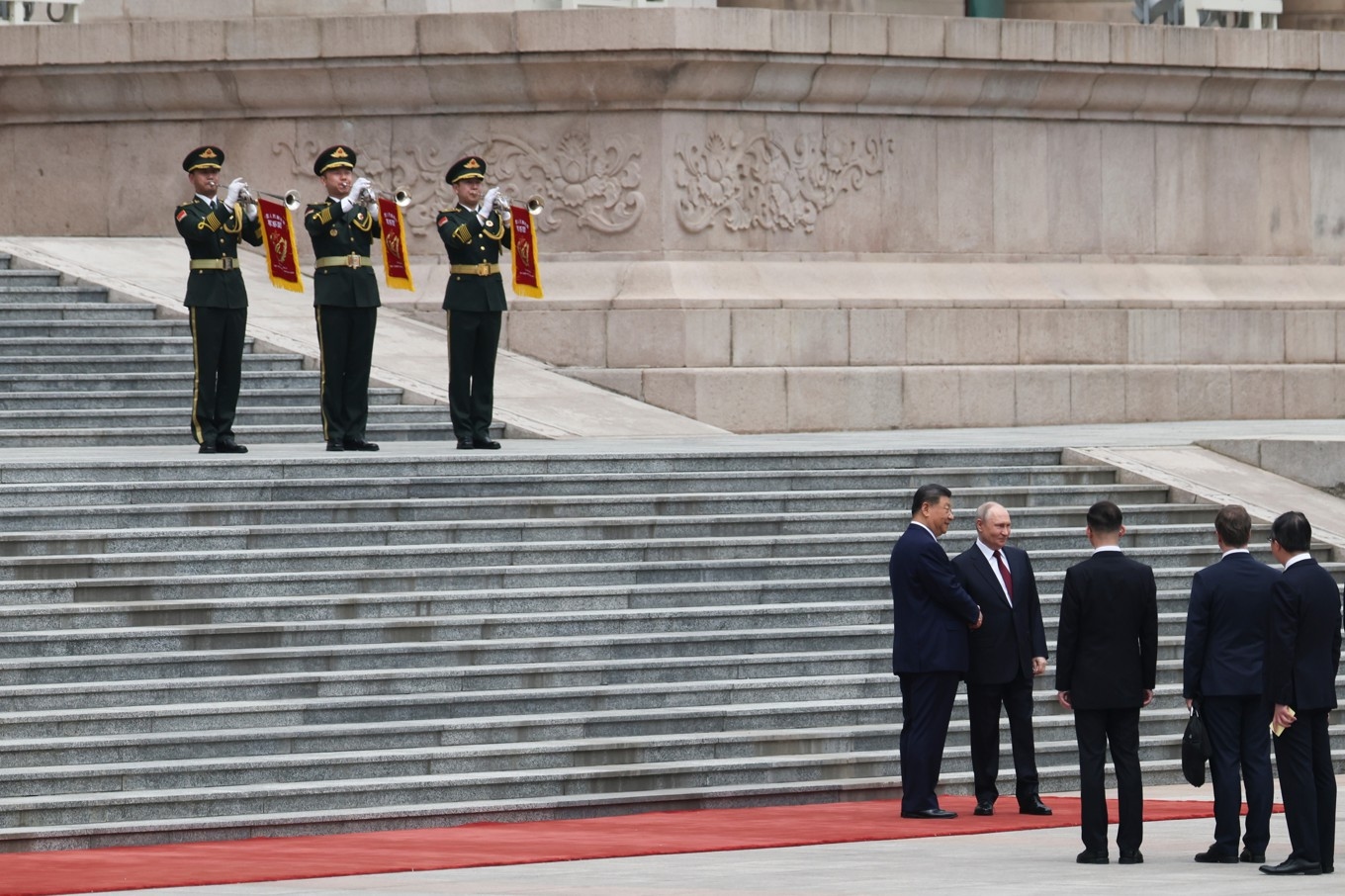 Vladimir Putin och Xi Jinping skakar hand utanför Folkets stora sal i Peking. Foto: Maxim Shemetov/AP/TT