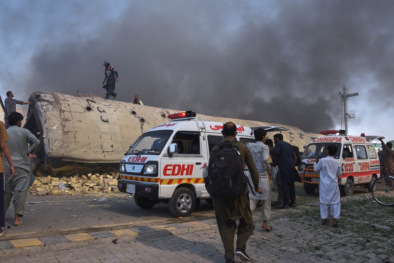 Volontärer letar efter offer från en vält tågvagn drabbad av en bombattack i Quetta, Pakistan. Foto: Arshad Butt /AP/TT
