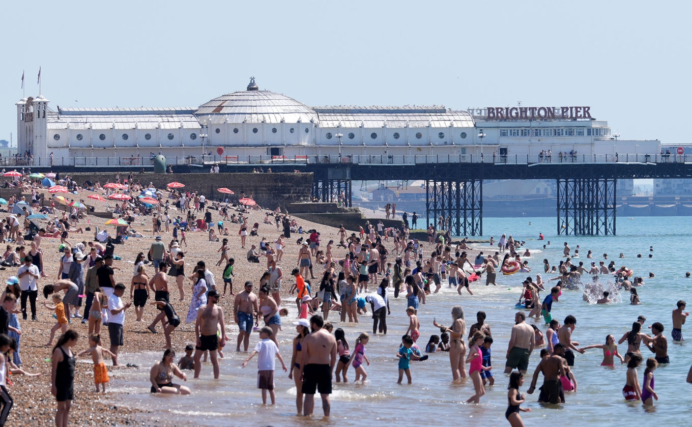 Många passade på att söka sig till stranden under den varma tisdagen. I Brighton var det drygt 26 grader. Foto: Gareth Fuller/PA/AP/TT