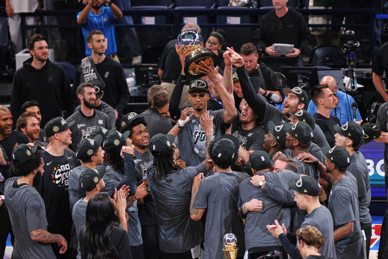 San Antonios Victor Wembanyama håller upp bucklan som mästare i västra konferensen efter segern mot Oklahoma City. Foto: Nate Billings/AP/TT