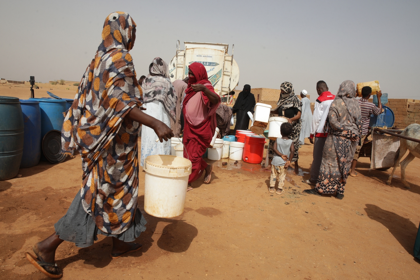 Människor på flykt i inbördeskrigets Sudan får vatten i en hjälpsändning. Foto: Marwan Ali /AP/TT