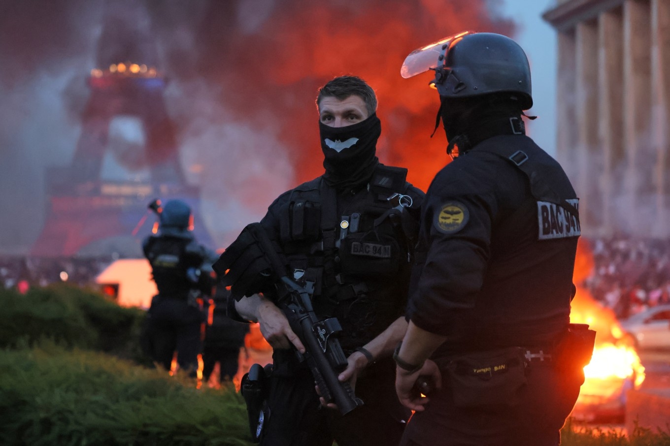 Poliser vid en bil som sattes i brand i samband med firandet av PSG:s Champions League-segern. Foto: Thomas Padilla /AP/TT