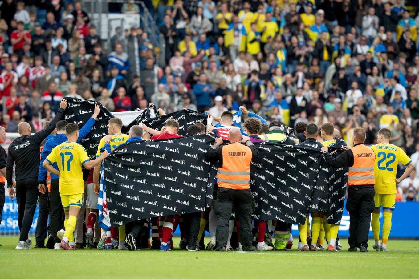 Danska och ukrainska spelare bildade en ring kring Christian Eriksen när fotbollsspelaren fick vård på planen i Odense. Foto: Bo Amstrup/AP/TT