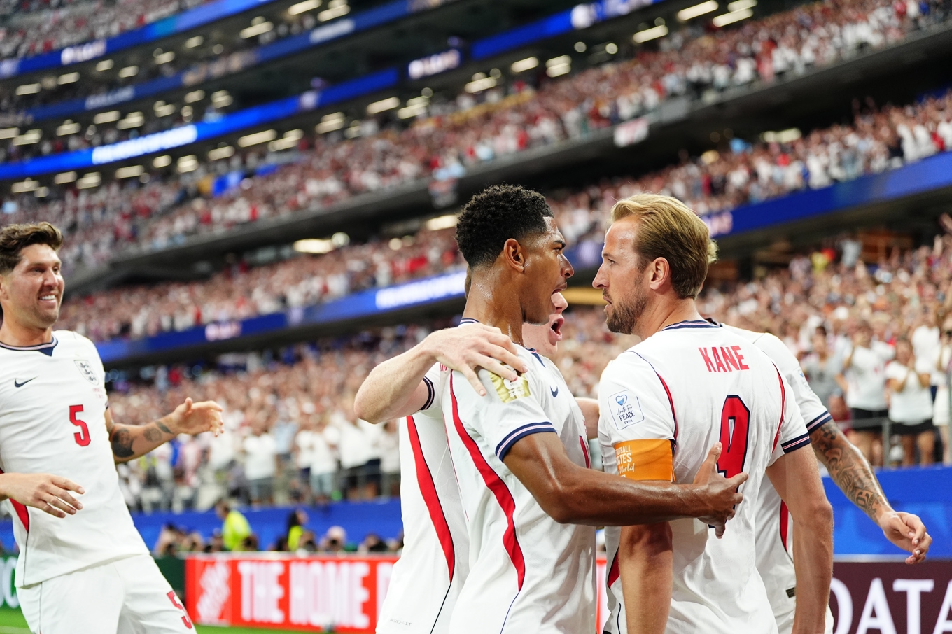Harry Kane firar 1–0-målet med John Stones (nummer 5) och Jude Bellingham. Foto: Björn Larsson Rosvall/TT