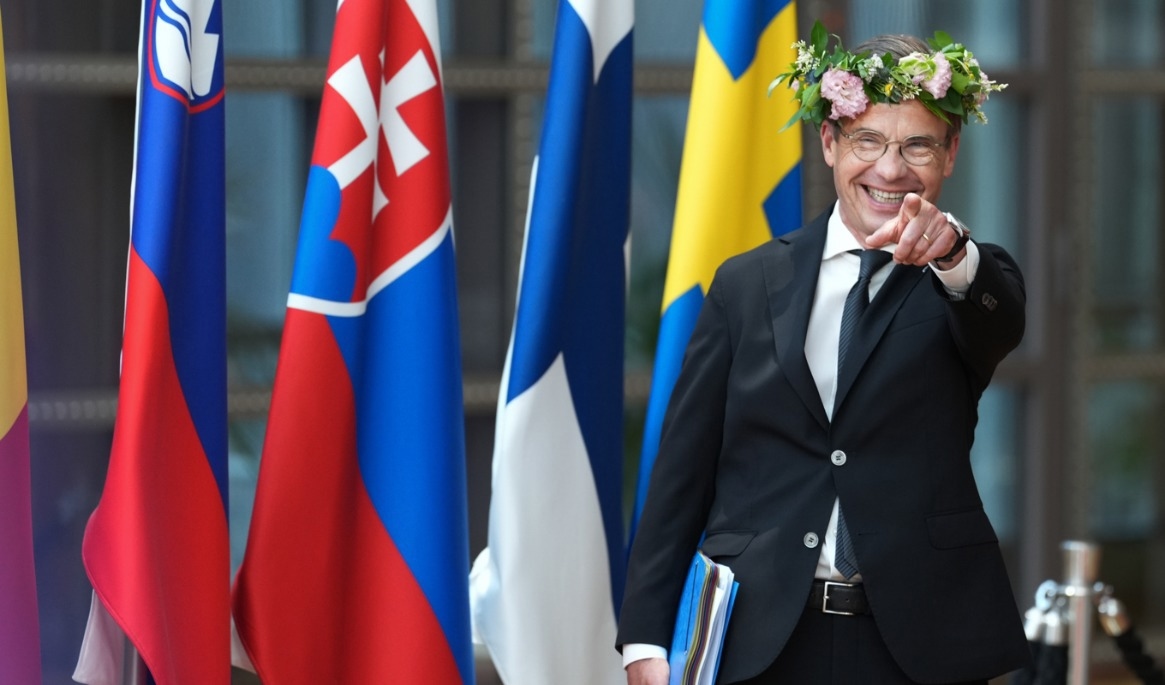 Statsminister Ulf Kristersson – med midsommarkrans i håret – på väg in till fredagens fortsatta EU-toppmöte i Bryssel. Foto: Marius Burgelman/AP/TT
