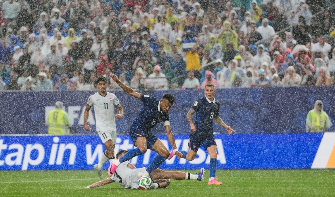 Regnet öste ned över planen under matchen mellan Irak och Frankrike. Foto: Matt Slocum/AP/TT