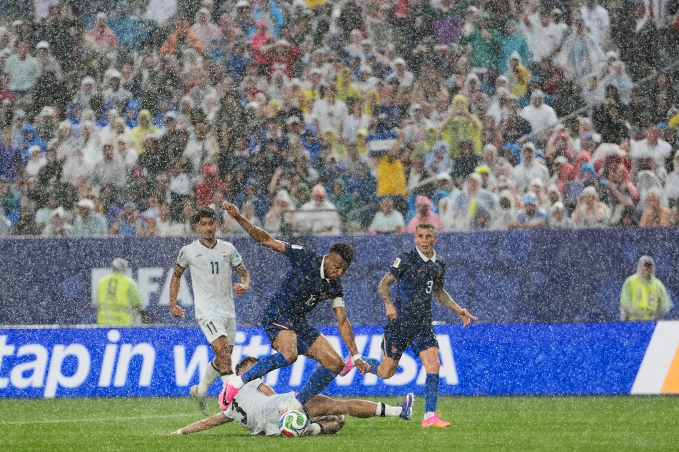 Regnet öste ned över planen under matchen mellan Irak och Frankrike. Foto: Matt Slocum/AP/TT