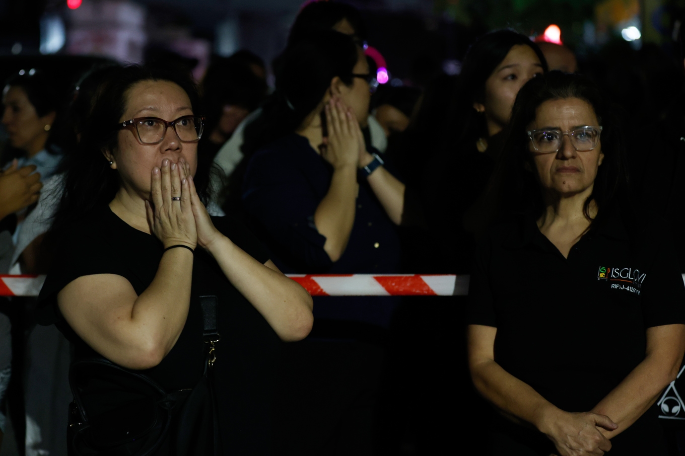 Skräckslagna invånare vid avspärrningar runt en raserad byggnad i Caracas efter skalven. Foto: Pedro Mattey/AP/TT