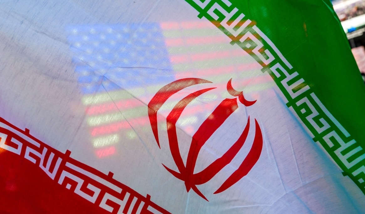 En amerikansk flagga syns genom Irans flagga under en protest mot kriget i New York i april. Foto: Ryan Murphy/AP/TT