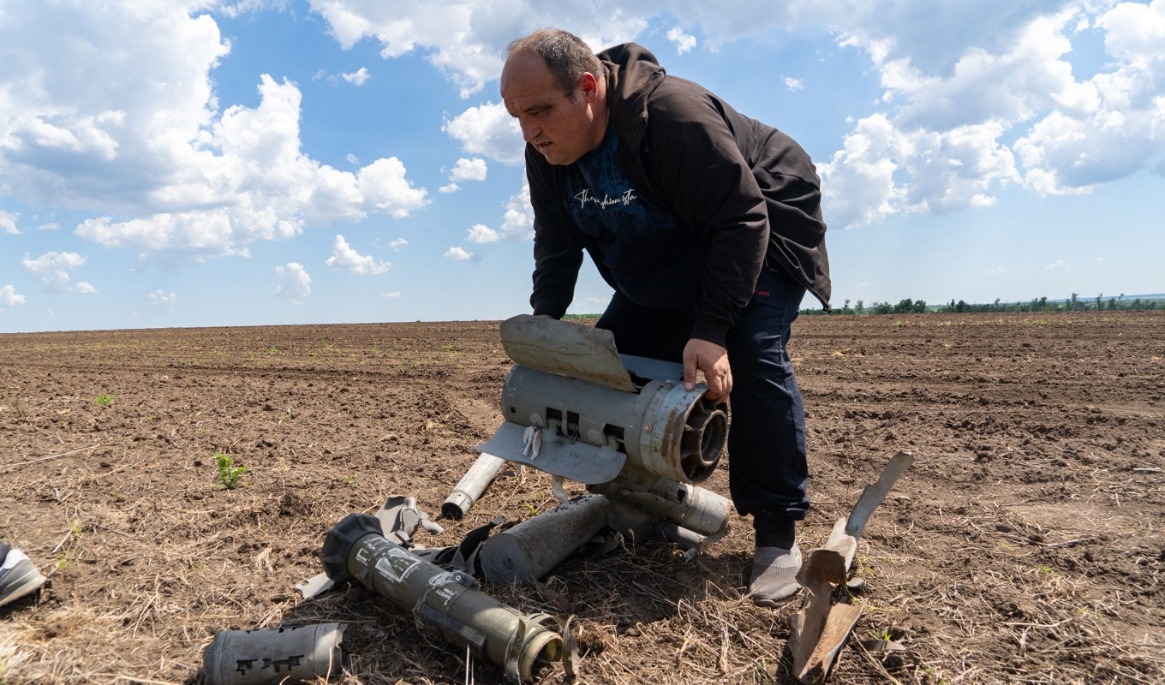 En lantbrukare lyfter undan vrakdelar från en rysk robot från ett fält i nordöstra Ukraina. Bilden togs den 22 maj. Foto: Andrii Marienko/AP/TT