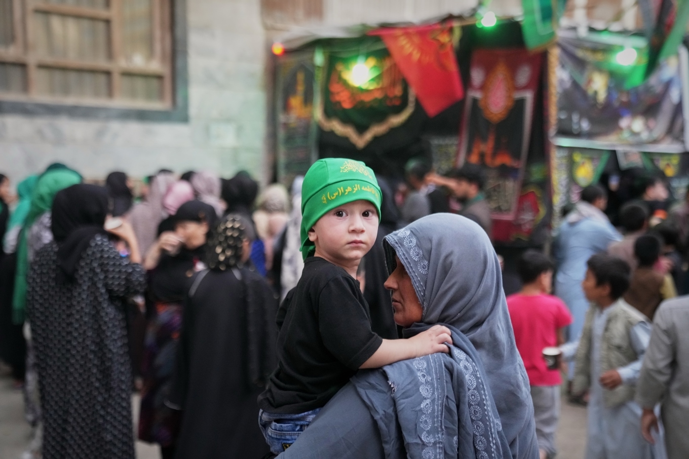 En kvinna bär ett barn vid firandet av den shiitiska högtiden Ashura i Kabul i fredags. Foto: Siddiqullah Alizai /AP/TT