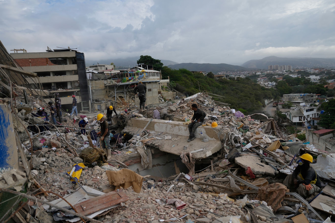 Räddningsarbetare bland spillror av byggnader i La Guaira i Venezuela i måndags. Foto: Ariana Cubillos/AP/TT