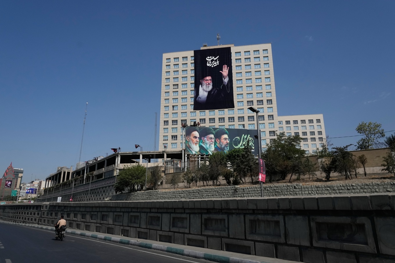 En affisch på ayatollah Ali Khamenei, som dödades i början av kriget, hänger på en byggnad i Teheran. Foto: Vahid Salemi /AP/TT