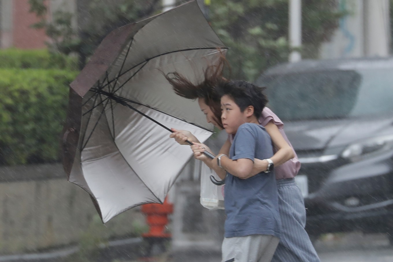 En pojke i Taichung i centrala Taiwan skyddar sig mot vinden. Foto: Chiang Ying-ying/AP/TT