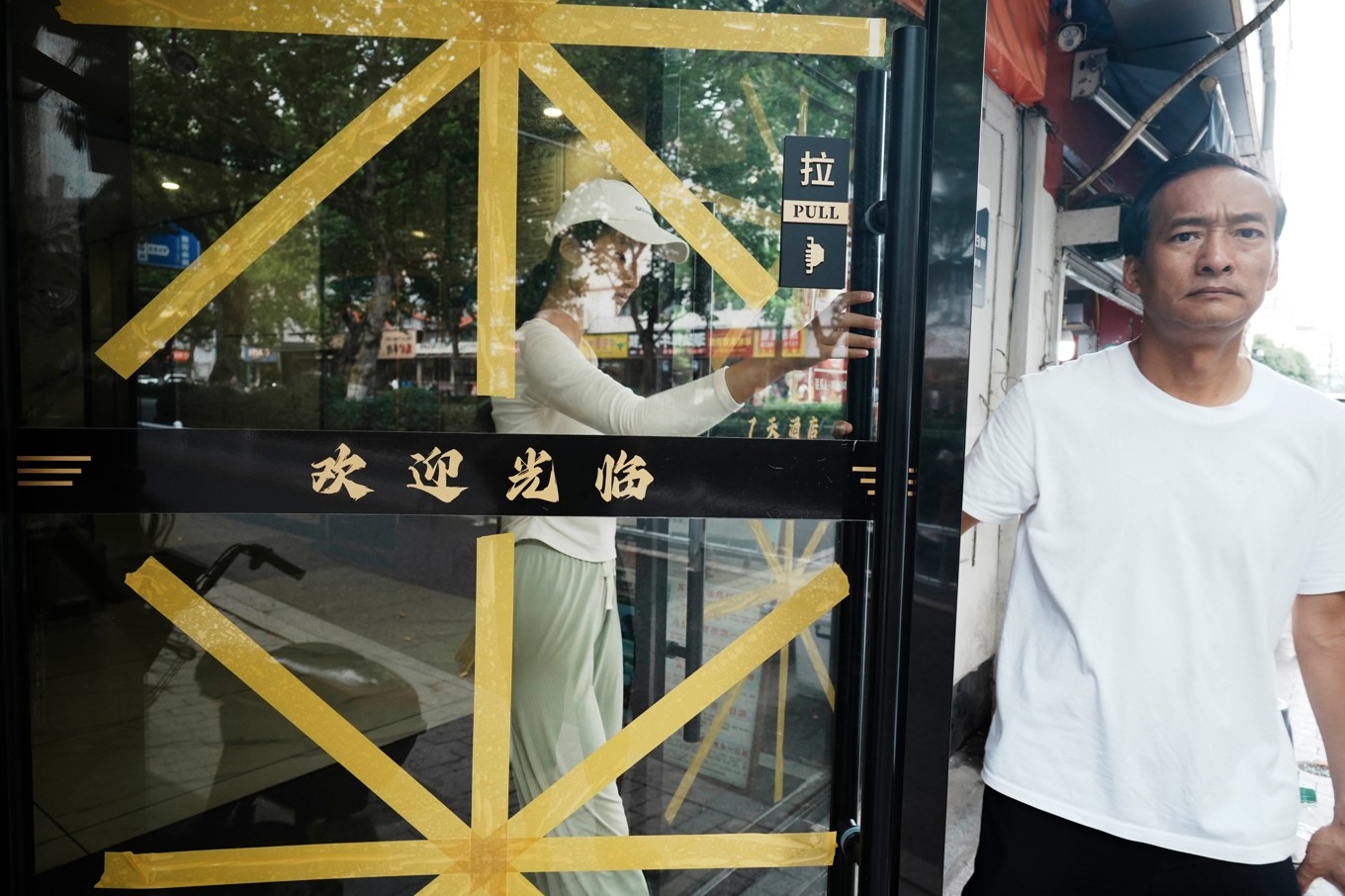 Glasdörrar tejpas inför tyfonen Bavis ankomst i Hangzhou i östra Kina. Foto: Chinatopix /AP/TT