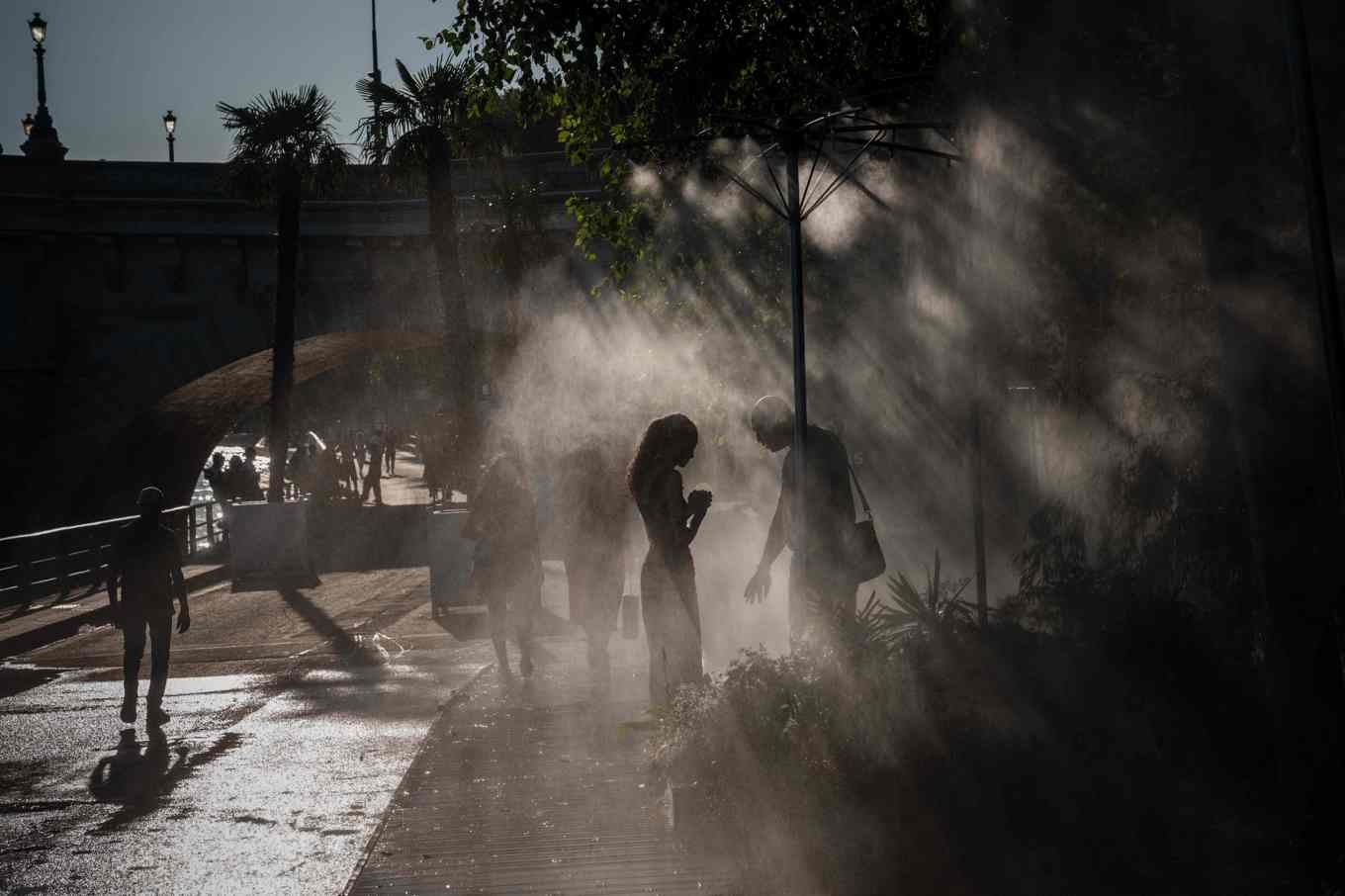 Människor i Paris svalkar sig på fredagen. Myndigheterna har utfärdat röd värmevarning i den franska huvudstaden. Foto: Dimitar Dilkoff/AFP/TT