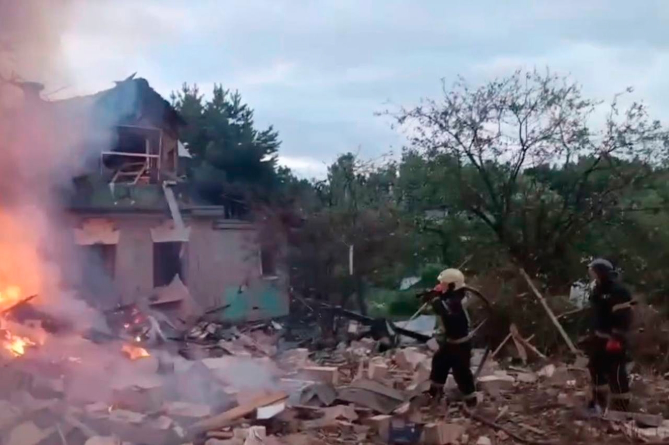 Brandmän kämpar med att släcka elden i ett hus i Moskvaregionen efter ukrainska attacker, natten till måndagen. Bilden kommer från regionens guvernörs Telegramkonto. Foto: Moskvaregionens guvernörs Telegramkonto/AP/TT
