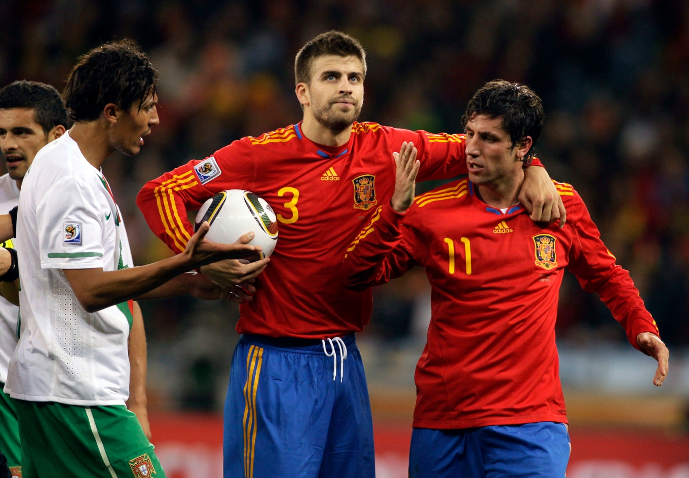 Spaniens Gerrard Pique (i mitten) och Joan Capdevila (till höger) under en match mot Portugal i fotbolls-VM i Sydafrika 2010. Foto: Ivan Sekretarev/AP/TT
