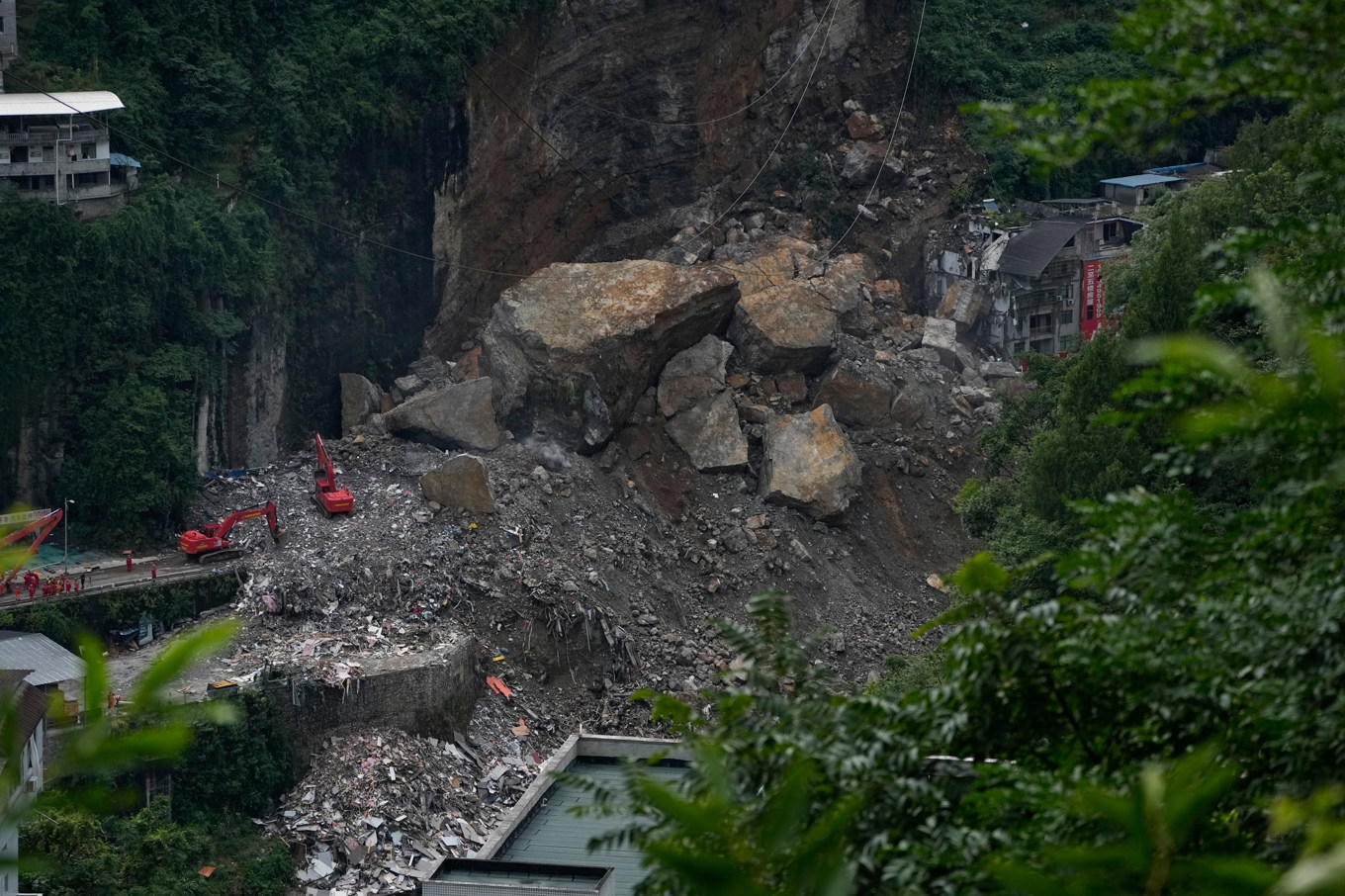 Stora mängder berg, sten och jord slungades ned från en bergssida och begravde flera bostadshus i den kinesiska staden Chongqing. Bild från 19 juli. Foto: Andy Wong/AP/TT