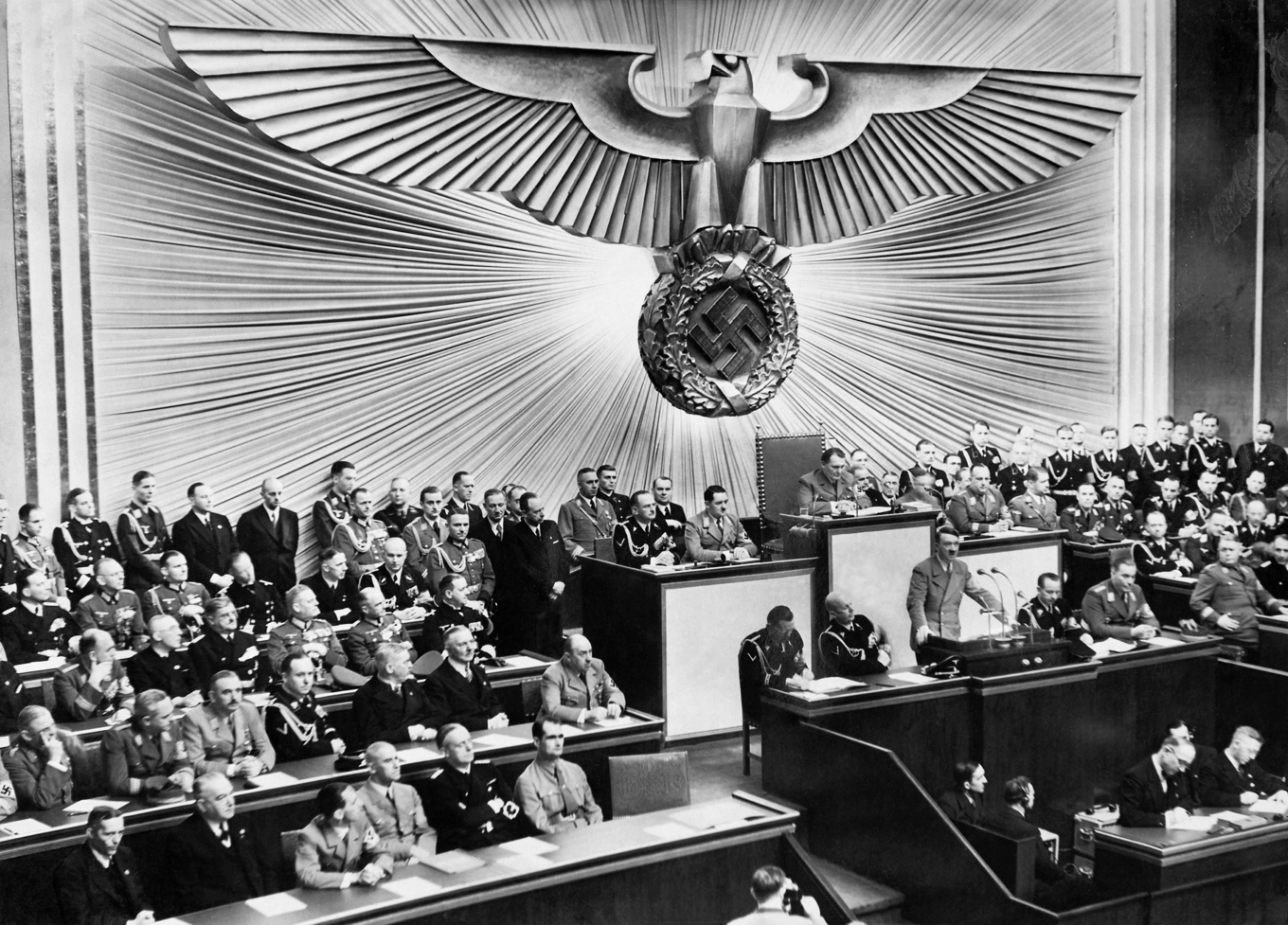 Adolf Hitler håller tal i Riksdagshuset i Berlin 1939. I örnen och svastikan syns influenser från både antiken och hinduismen. Foto: Wikimedia Commons