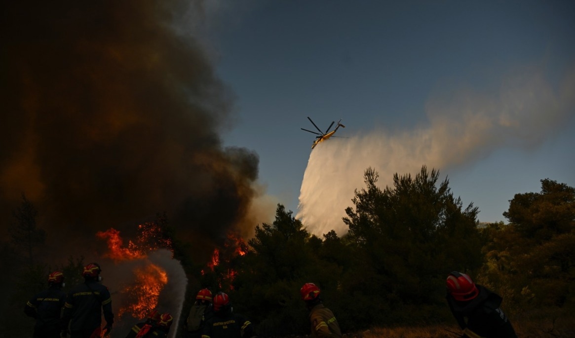 Helikoptrar och flygplan har satts in för att bekämpa bränderna kring bland annat Porto Germeno nordväst om Aten. Foto: Michael Varaklas/AP/TT