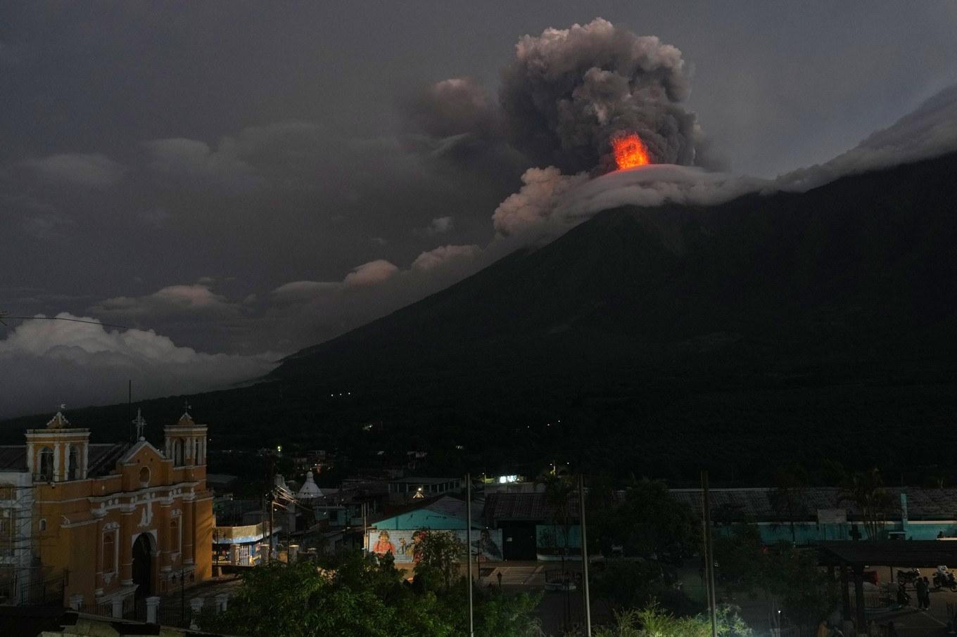 Vulkanen Fuego fotad från San Juan Alotenangoi Guatemala. Lava och vulkaniska rökmoln syns stiga upp mot himlen. Foto: Moises Castillo/AP/TT