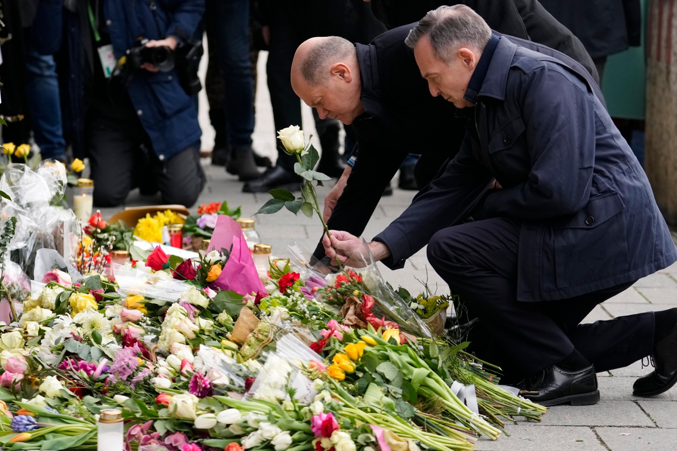 Tysklands dåvarande förbundskansler Olaf Scholz och trafikminister Volker Wissing vid minnesplatsen där bilattentatet inträffade. Bilden togs två dagar efter dådet. Foto: Ebrahim Noroozi/AP/TT