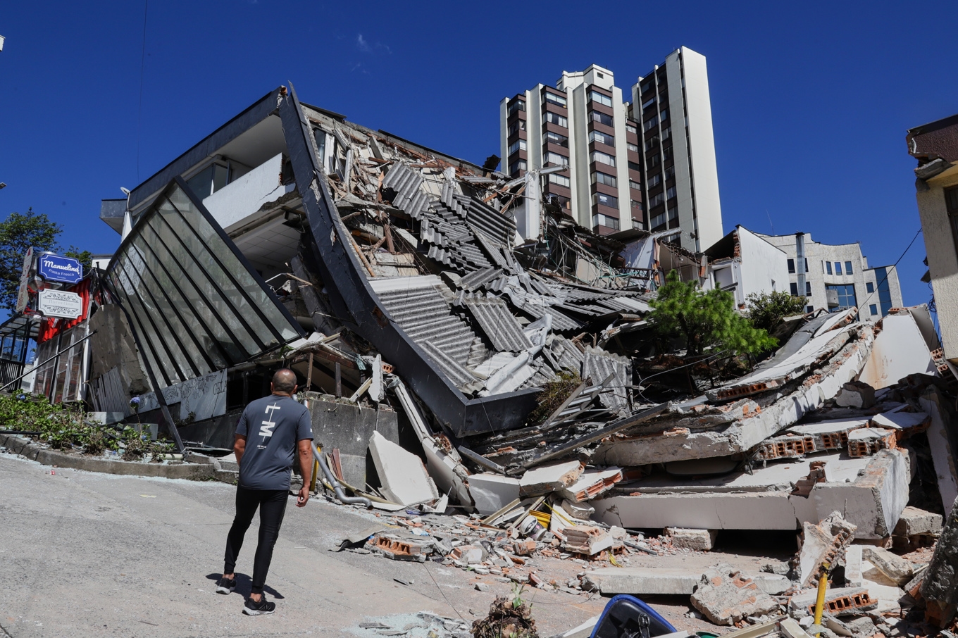 En man tittar på en förstörd byggnad efter att en jordbävning drabbat Manizales i Colombia. Foto: Dario Cardona/AP/TT