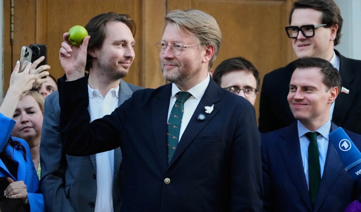 Det ryska oppositionspartiet Jablokos partiledare Nikolaj Rybakov håller i ett äpple, partiets symbol. Foto: Pavel Bednyakov/AP/TT