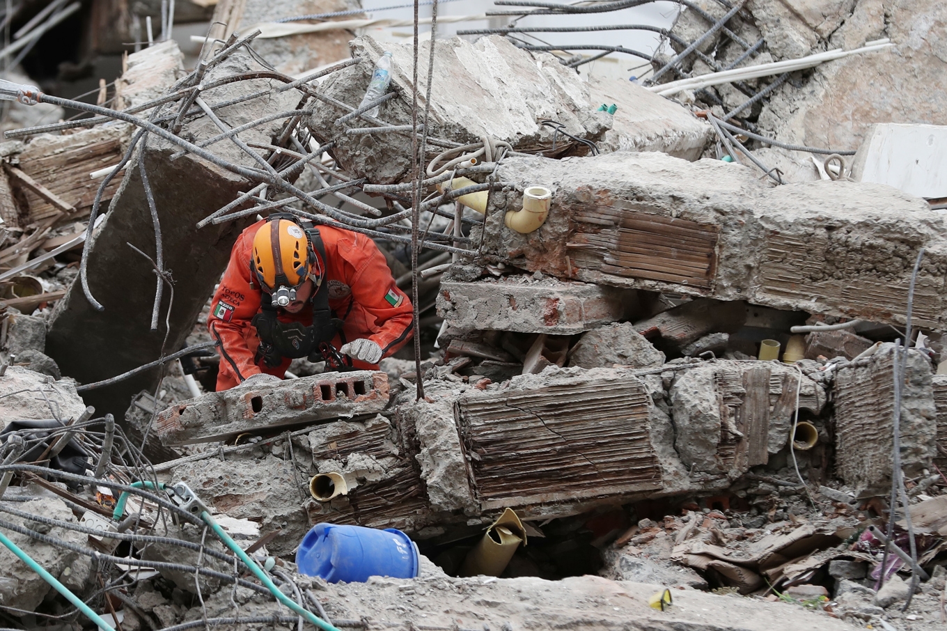En räddningsarbetare letar igenom rasmassorna efter jordbävningen. Foto: Santiago Saldarriaga/AP/TT
