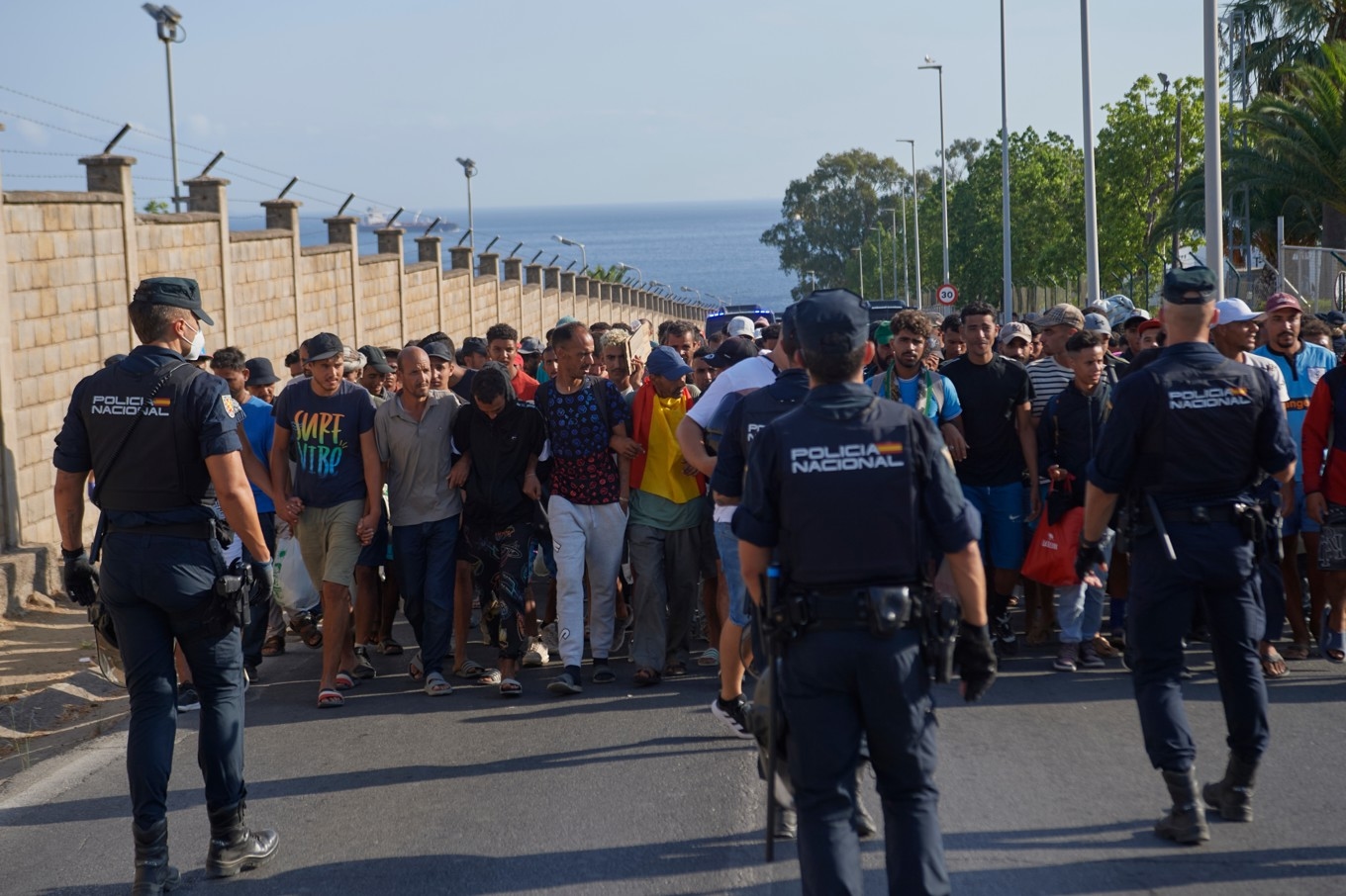 Migranter eskorteras till tillfälliga förvar i Ceuta av spansk polis på torsdagen. Foto: Antonio Sempere/AP/TT