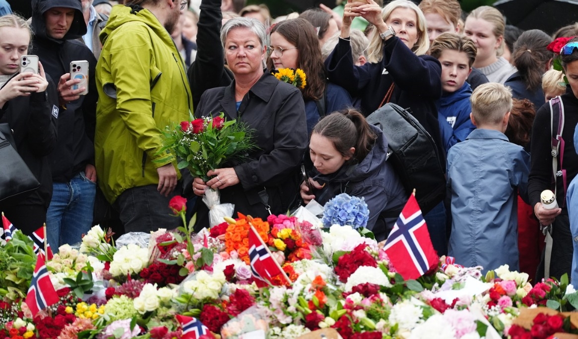 Sörjande norrmän lämnar blommor och ljus framför Kungliga slottet i Oslo efter beskedet att Norges kung Harald dött. Foto: Björn Larsson Rosvall/TT