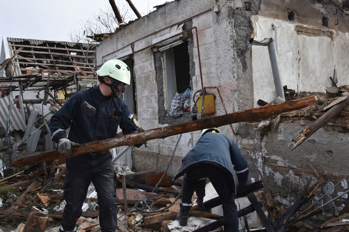 Räddningsarbetare röjer bråte efter en drönarattack mot ett bostadsområde i Zaporizjzja i mars i år. Foto: Andriy Andriyenko/AP/TT