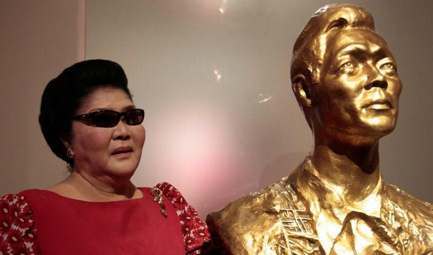 Den före detta presidentfrun Imelda Marcos står bredvid en byst av maken, diktatorn Ferdinand Marcos, som avled i exil 1989. Foto: Aaron Favila/AP/TT-arkivbild