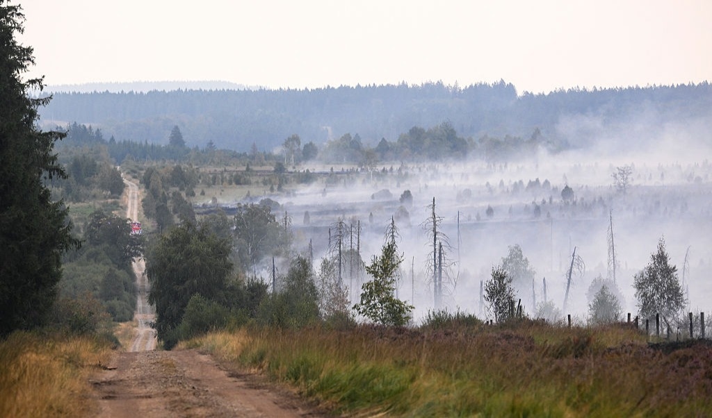 Rök stiger från de branddrabbade markerna i Hautes Fagnes, Belgien. Branden tros kunna fortsätta blossa upp igen under lång tid. Foto: John Thys / AFP via Getty Images