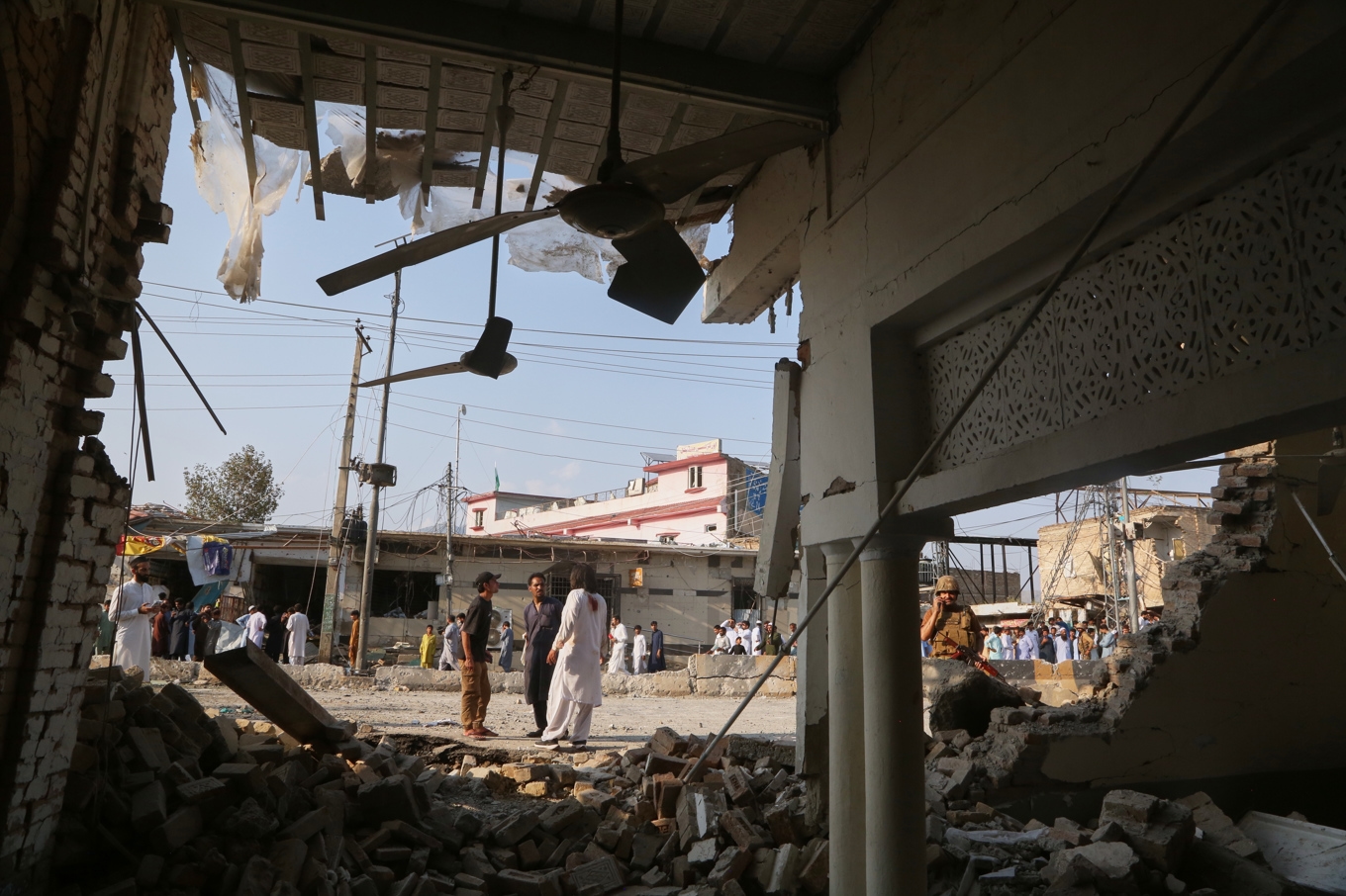 En soldat och lokalinvånare utanför moskén där en bomb exploderade under fredagen i nordvästra Pakistan. Foto: Muhammad Sajjad/AP/TT