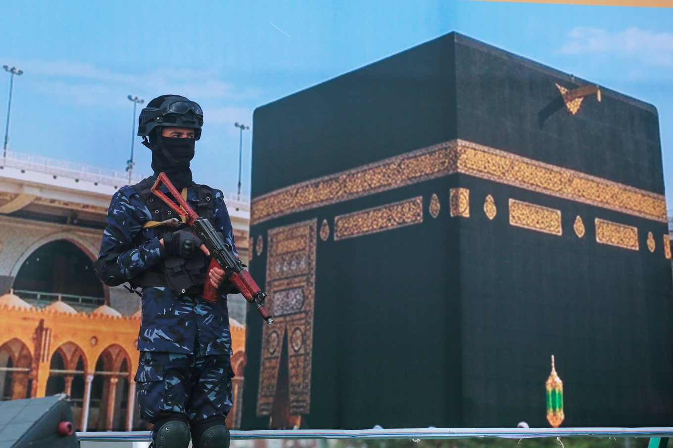 En stridande huthier framför en jätteaffisch på Kaba i Mekka, under en protest mot Saudiarabiens anklagelse om en huthiattack mot muslimernas viktigaste helgedom. Bild tagen i Sanaa i fredags. Foto: Osamah Abdulrahman/AP/TT