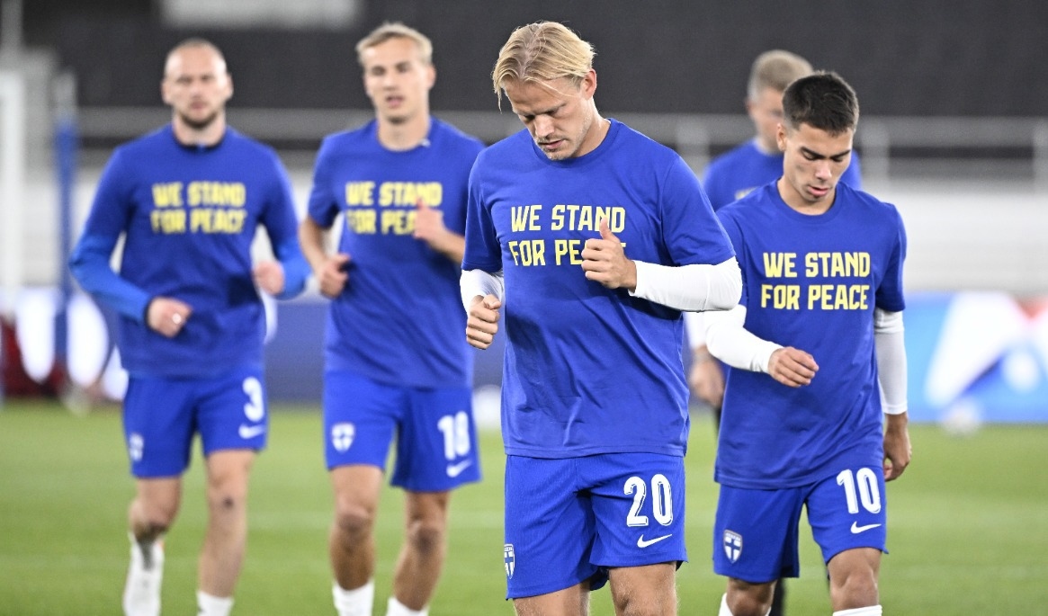 Finländska spelare med tröjor under uppvärmningen för att stötta Ukraina. Foto: Roni Rekomaa/Lehtikuva/TT