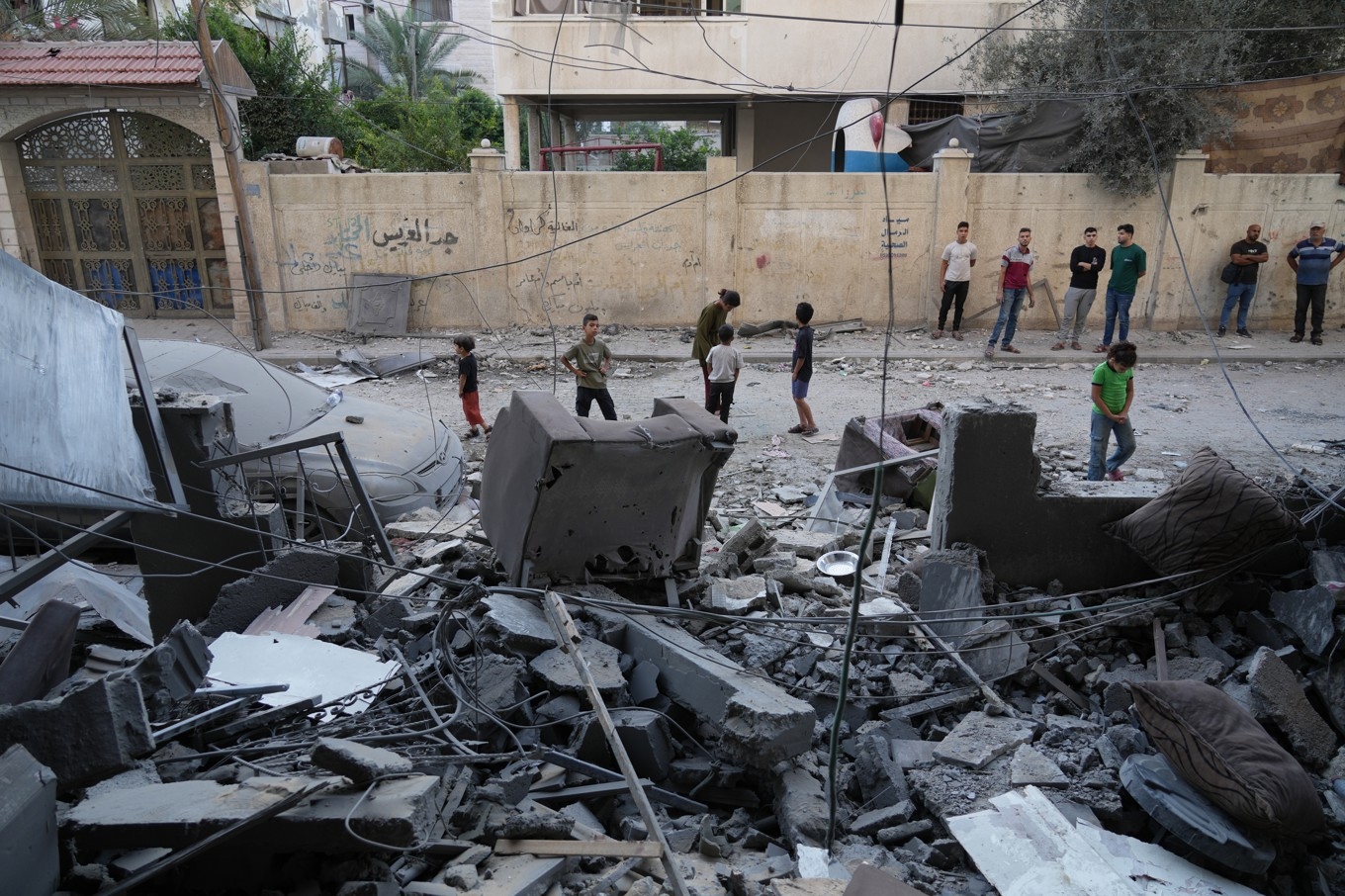 Palestinier vid platsen för den israeliska flygattack som ägde rum tidigt på morgonen i Gaza stad på lördagen. Foto: Jehad Alshrafi/AP/TT