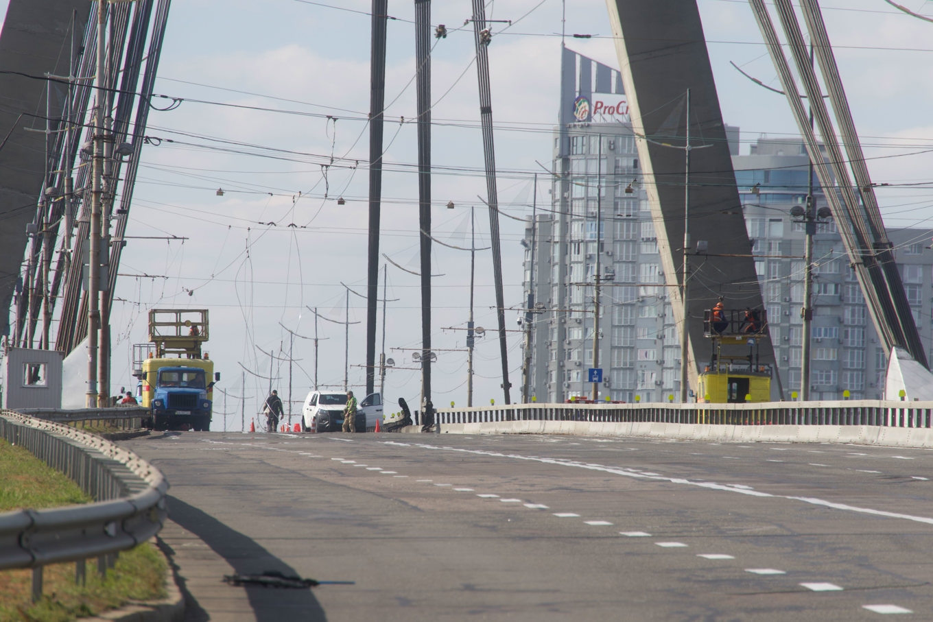 Polis i Ukrainas huvudstad Kiev inspekterar skadorna på en bro efter en rysk drönarattack. Bilden togs i söndags. Foto: Andriy Dubchak/AP/TT